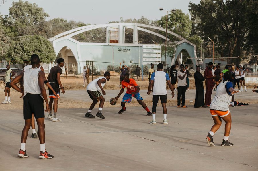 Young people playing basketball on a community court